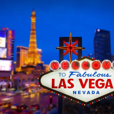 A photo of the Las Vegas sign behind the city landscape