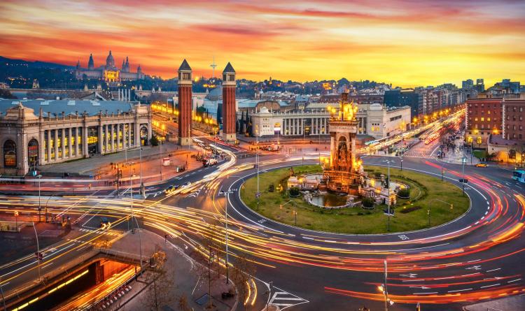 Long exposure photo of Fira de Barcelona, Plaça d'espanya (Spain square) and montjuic mountain in Barcelona at sunset with car light trails . Spain
