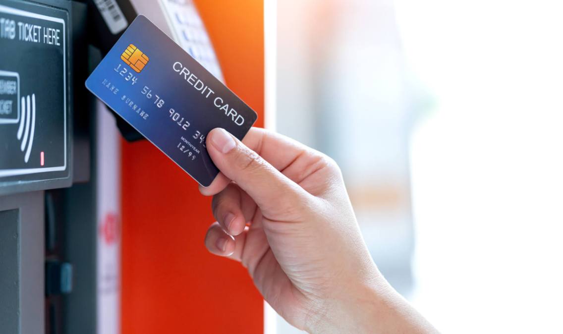 A photo of a person placing a credit card near merchant register