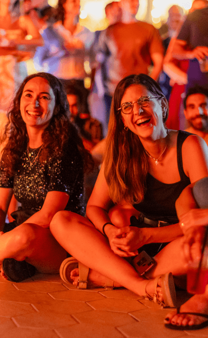 A photo of two Orca colleagues laughing during an event